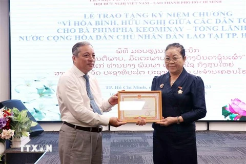 Trao Kỷ niệm chương “Vì hòa bình, hữu nghị giữa các dân tộc” của Liên hiệp các tổ chức hữu nghị Việt Nam cho bà Phimpha Keomixay, Tổng lãnh sự Lào tại Thành phố Hồ Chí Minh. (Ảnh: Xuân Khu/TTXVN)
