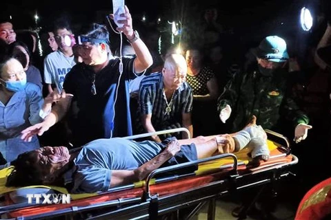 Ngư dân Nguyễn Ngọc được các lực lượng và gia đình hỗ trợ đưa đi bệnh viện cấp cứu, điều trị. (Ảnh: TTXVN phát)