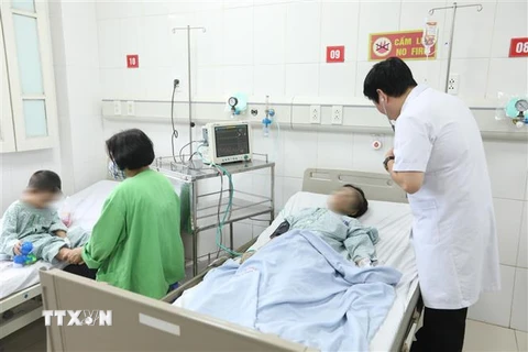 Bác sỹ Bệnh viện Đa khoa Xanh Pôn thăm khám cho bệnh nhân trong vụ cháy chung cư mini. (Ảnh: Minh Quyết/TTXVN)