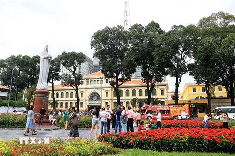 Khách quốc tế vui chơi trong vườn hoa trước Bưu điện Trung tâm và Nhà thờ Đức Bà Thành phố Hồ Chí Minh. (Ảnh: Hồng Đạt/TTXVN)