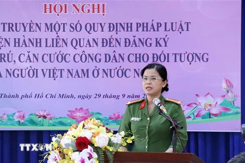 Trung tá Nguyễn Thị Hồng Châu, Phòng Cảnh sát Quản lý Hành chính về Trật tự Xã hội Thành phố Hồ Chí Minh (PC06), giới thiệu Luật Cư trú. (Ảnh: Xuân Khu/TTXVN)
