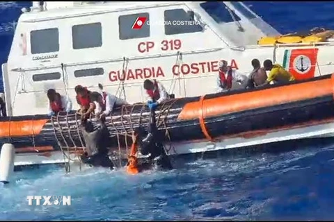 Tàu của Lực lượng Bảo vệ Bờ biển Italy giải cứu người di cư và tìm kiếm thi thể các nạn nhân ở ngoài khơi đảo Lampedusa, ngày 5/8. (Ảnh: AFP/TTXVN)