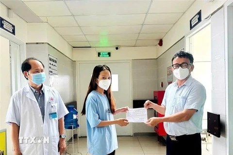 Bác sỹ Huỳnh Minh Chín, Phó Giám đốc Sở Y tế tỉnh Bình Dương, trao Giấy xuất viện cho bệnh nhân đậu mùa khỉ đã lành bệnh. (Ảnh: TTXVN phát)