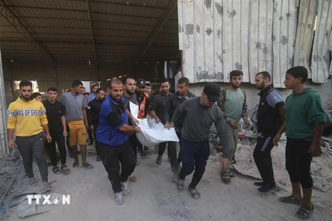 Chuyển thi thể nạn nhân thiệt mạng sau cuộc không kích của Israel xuống thành phố Rafah ở Dải Gaza. (Ảnh: THX/TTXVN)