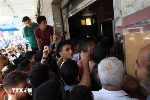 Người dân xếp hàng chờ nhận thức ăn cứu trợ tại Dải Gaza. (Ảnh: THX/TTXVN)