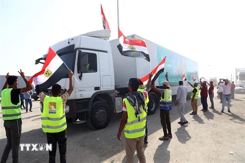 Xe tải chở hàng viện trợ di chuyển từ Ai Cập qua cửa khẩu Rafah vào Dải Gaza. (Ảnh: THX/TTXVN)