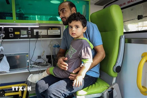 Em nhỏ bị thương chờ được đưa tới bệnh viện ở Ai Cập qua cửa khẩu Rafah. (Ảnh: THX/TTXVN)