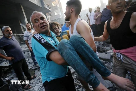 Chuyển người bị thương sau cuộc không kích của Israel xuống thị trấn Deir Al-Balah, Dải Gaza. (Ảnh: AFP/TTXVN)
