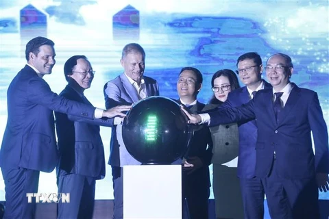 Đại biểu thực hiện nghi thức "Thắp sáng xanh lam” lên tòa nhà Bưu điện Hà Nội. (Ảnh: Minh Quyết/TTXVN)