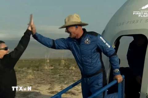 Tỷ phú người Mỹ Jeff Bezos (phải) rời tàu vũ trụ New Shepard sau khi con tàu hạ cánh an toàn trên sa mạc Texas ngày 20/7/2021. (Ảnh: AFP/TTXVN)