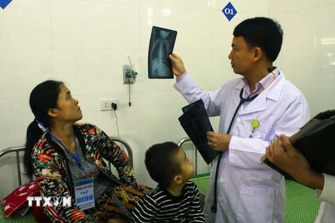 Bác sỹ Bệnh viện Sản nhi Nghệ An xem phim chụp XQ của bệnh nhi. (Ảnh: Tá Chuyên/TTXVN) 