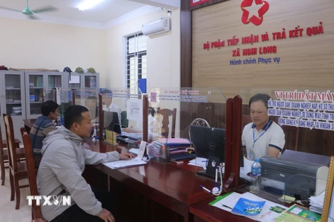 Người dân đến làm thủ tục hành chính tại bộ phận một cửa xã Nghi Long (Nghi Lộc, Nghệ An). (Ảnh: Bích Huệ/TTXVN)