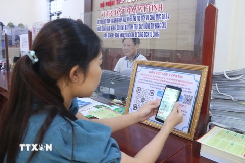 Người dân quét mã QR để góp ý online. (Ảnh: Bích Huệ/TTXVN)