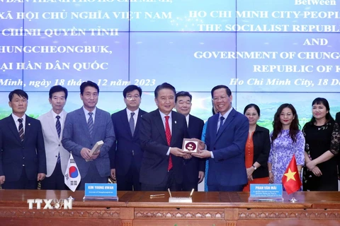 Ông Phan Văn Mãi (bên phải), Chủ tịch Ủy ban Nhân dân Thành phố Hồ Chí Minh trao tặng quà cho ông Kim Yong Hwan, Tỉnh trưởng tỉnh Chungcheongbuk, Hàn Quốc. (Ảnh: Xuân Khu/TTXVN)