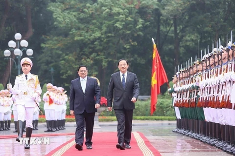 Thủ tướng Phạm Minh Chính và Thủ tướng Lào Sonexay Siphandone duyệt Đội danh dự Quân đội Nhân dân Việt Nam. (Ảnh: Dương Giang/TTXVN)