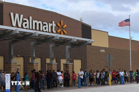 Người dân xếp hàng bên ngoài cửa hàng Walmart ở Houston, Texas, Mỹ. (Ảnh: AFP/TTXVN)