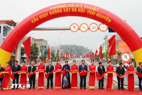 Các đại biểu thực hiện nghi thức cắt băng thông xe kỹ thuật cầu vượt đường sắt Hà Nội-Thái Nguyên. (Ảnh: Hoàng Nguyên/TTXVN)