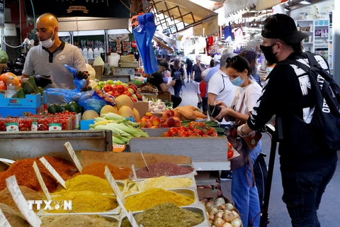 Người dân mua sắm tại một khu chợ ở thành phố Tel Aviv, Israel. (Ảnh: AFP/TTXVN)