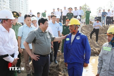 Thủ tướng Phạm Minh Chính chúc Tết công nhân, người lao động đang thi công đường Vành đai 3 đoạn qua Thành phố Hồ Chí Minh. (Ảnh: Dương Giang/TTXVN)