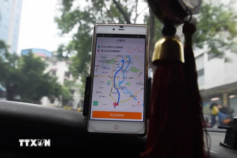 Tài xế taxi sử dụng ứng dụng gọi xe Didi Chuxing tại Quế Lâm, Trung Quốc. (Ảnh: AFP/TTXVN)