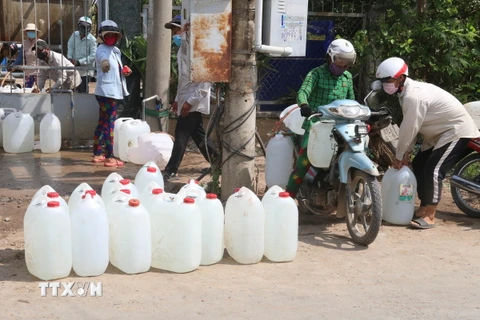 Nhân dân đến lấy nước từ một điểm cấp nước miễn phí ở xã Long Bình, huyện Gò Công Tây. (Ảnh: Minh Trí/TTXVN)
