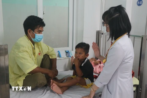 Bác sỹ kết hợp thăm, khám với tuyên truyền cho phụ huynh về cách phòng, chống bệnh trên trẻ em. (Ảnh: Dư Toán/TTXVN)