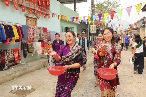 Những cô gái dân tộc Lào té nước cầu may. (Ảnh: Xuân Tư/TTXVN)