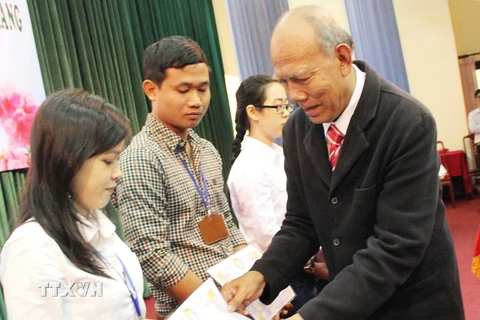 Nhà giáo Nhân dân Lâm Es trong một lần tặng học bổng cho học sinh. (Ảnh: Trung Hiếu/TTXVN)