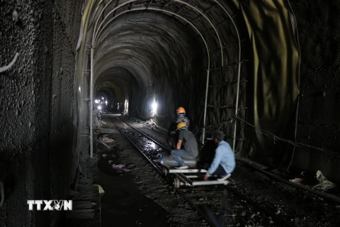 Công nhân nỗ lực vận chuyển đất đá, đưa vật liệu vào gia cố hầm Đèo Cả. (Ảnh Đặng Tuấn/TTXVN)