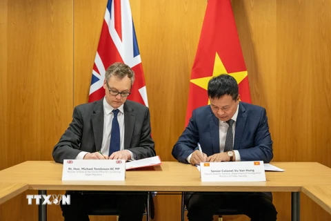 Đại tá Vũ Văn Hưng (phải) và Thứ trưởng Michael Tomlinson ký Tuyên bố chung về hợp tác phòng chống di cư bất hợp pháp tại London. (Ảnh: Bộ Nội vụ Anh cung cấp)