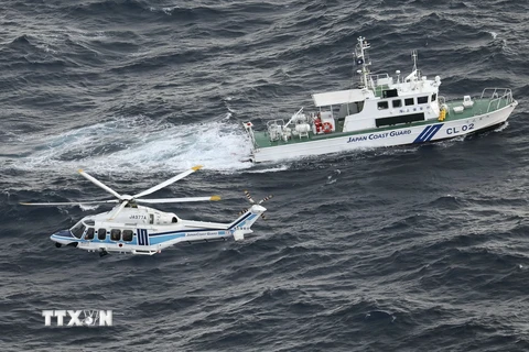 Tàu và trực thăng của Lực lượng Bảo vệ bờ biển Nhật Bản làm nhiệm vụ ở ngoài khơi đảo Yakushima. (Ảnh: Kyodo/TTXVN)