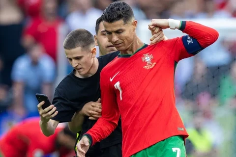 Một cổ động viên lao xuống sân, cố chụp ảnh selfie với Cristiano Ronaldo. (Nguồn: Getty Images)