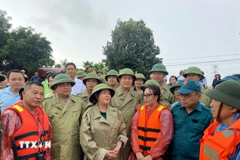 Bà Bùi Thị Minh Hoài, Bí thư Thành ủy Hà Nội (đứng giữa), trao đổi, động viên lực lượng xung kích phòng chống lũ tại huyện Quốc Oai. (Ảnh: Nguyễn Văn Cảnh/TTXVN)