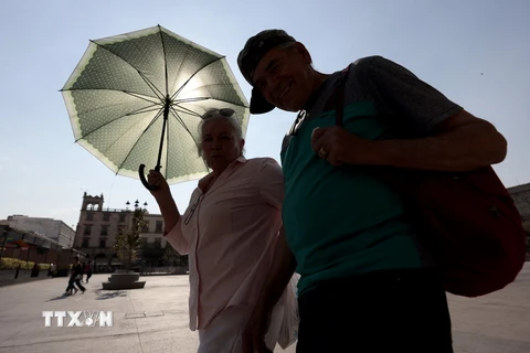 Người dân di chuyển dưới trời nắng nóng tại bang Jalisco, Mexico. (Ảnh: AFP/TTXVN)