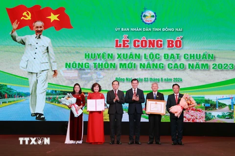 Phó Thủ tướng Trần Lưu Quang (thứ 3, trái sang) trao Quyết định của Thủ tướng Chính phủ công nhận Huyện nông thôn mới nâng cao cho lãnh đạo huyện Xuân Lộc, Đồng Nai. (Ảnh: Lê Xuân/TTXVN)