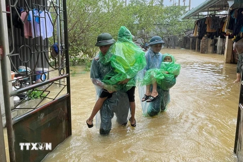 Lực lượng chức năng giúp người dân Chương Mỹ (Hà Nội) di chuyển đến những nơi an toàn. (Ảnh: TTXVN phát)