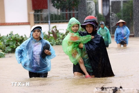 Người dân thôn Ấp Nhập, xã Thọ An, huyện Đan Phượng di chuyển khỏi vùng ngập lụt (ảnh chụp lúc 12h23). (Ảnh: Huy Hùng/TTXVN)