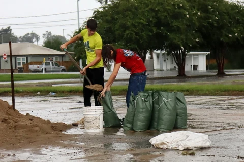 Người dân sử dụng bao cát để gia cố nhà cửa và ngăn lũ lụt tại Houma, Louisiana, Mỹ. (Nguồn: AFP)