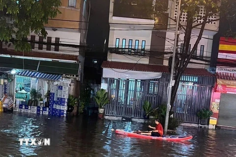 Người dân phải dùng thuyền để di chuyển tại khu vực ngã ba cống trên đường Thích Quảng Đức, thành phố Thủ Dầu Một, tỉnh Bình Dương. (Ảnh: TTXVN phát)