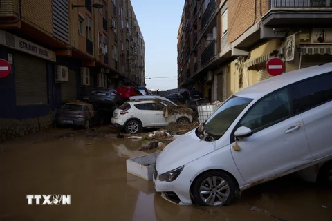 Ôtô bị cuốn trôi chồng lên nhau trên phố sau lũ quét tại Valencia, Tây Ban Nha. (Ảnh: THX/TTXVN)