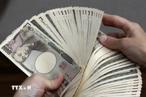 Kiểm tiền mệnh giá 10.000 yen tại Tokyo, Nhật Bản. (Ảnh: AFP/TTXVN)