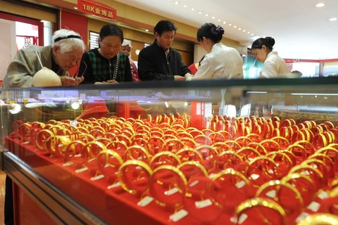 Khách hàng chọn mua đồ trang sức bằng vàng tại một cửa hàng tỉnh Giang Tô (Trung Quốc). (Ảnh: AFP/TTXVN)