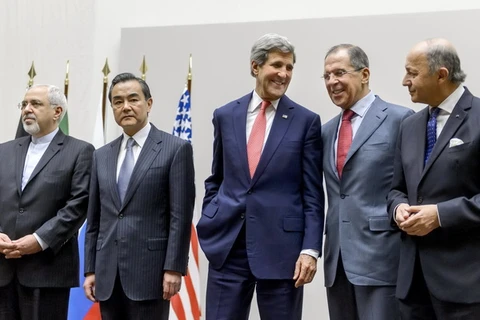 Đại diện của Iran và nhóm P5+1 sau khi đạt được thỏa thuận bước đầu về chương trình hạt nhân, ngày 24/11. (Ảnh: AFP/TTXVN)