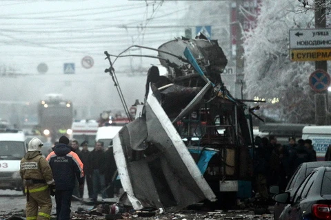 Nhân viên cứu nạn và nhân viên an ninh làm nhiệm vụ tại hiện trường vụ đánh bom ngày 30/12. (Ảnh: AFP/TTXVN)