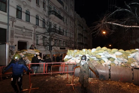 Người biểu tình chống Chính phủ dựng rào chắn bên ngoài trụ sở Bộ Nội vụ Ukraine ở Kiev ngày 27/1. (Ảnh: AFP/TTXVN)