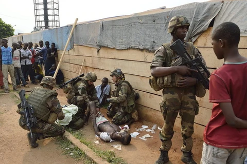 Binh sỹ Pháp giúp đỡ người bị thương trong các vụ cướp phá tại Bangui. (Ảnh: AFP/TTXVN)