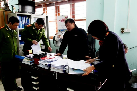 Cảnh sát khám xét nơi làm việc của vị can Phạm Thị Thành, Giám đốc Trung tâm cứu trợ trẻ em tàn tật tỉnh. (Ảnh: TTXVN)