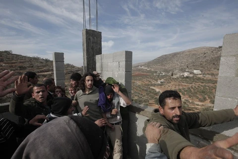 Người Palestine phản đối nhóm người Israel dựng các khu nhà tại khu vực Israel chiếm đóng ở khu Bờ Tây. (Ảnh: AFP/TTXVN)