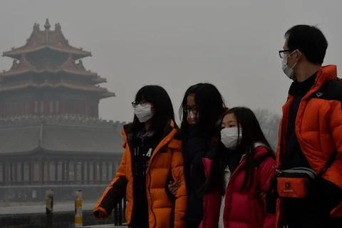 Khách du lịch đeo khẩu trang tránh bụi tại Bắc Kinh, Trung quốc ngày 26/2 vừa qua. (Ảnh: THX/TTXVN)