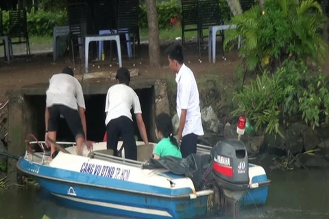 Cano của Trung tâm điều tiết giao thông Cảng vụ đường thủy nội địa Thành phố Hồ Chí Minh đưa người phụ nữ vào bờ. (Ảnh: Đặng Minh/Vietnam+)